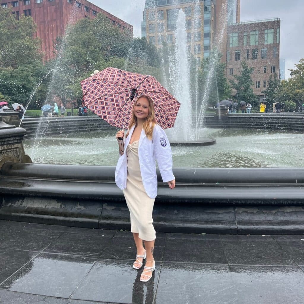 Alexandra Petersen with an umbrella by a fountain