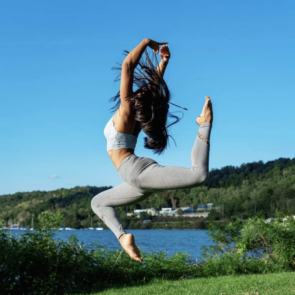 alyssa carbonell jumping in a field